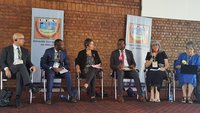 Sechs Menschen sitzen auf einem Podium einer internationalen Konferenz in DR Kongo.