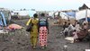 Two women walk through a refugee camp in eastern Congo.