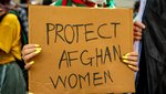 „Protect Afghan Women“ steht auf einem Protestschild, das eine Person in den Händen hält.