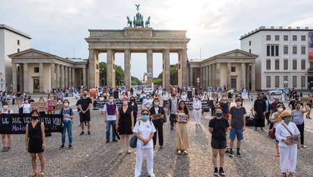 Teilnehmer:innen einer Mahnwache anlässlich des diesjährigen Internationalen Gedenktags für die sogenannten „Trostfrauen“vor dem Brandenburger Tor in Berlin.  