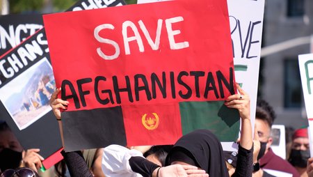 Eine Frau hält auf einer Demonstration ein Plakat mit der Aufschrift Save Afghanistan in die Höhe.
