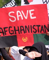 Eine Frau hält auf einer Demonstration ein Plakat mit der Aufschrift Save Afghanistan in die Höhe.