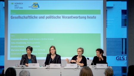 Four women on stage at a colloquium held by the Heinrich Böll Foundation. 