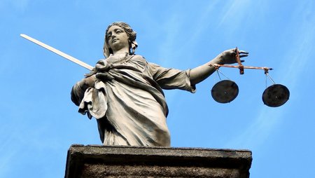 Justizia statue against blue sky