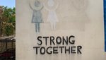 Ein Wandbild zeigt den Text "Strong together" - zusammen stark.