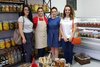 Vier Frauen posieren für ein Gruppenfoto in einem kleinen Geschäft