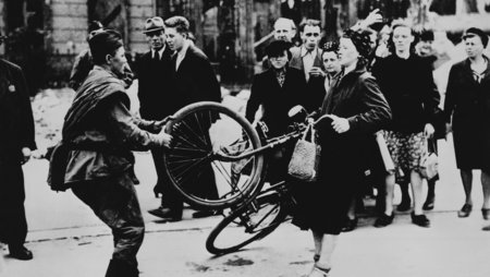 Ein russischer Besatzungssoldat will einer Berlinerin ihr Fahrrad entreißen (1945). 