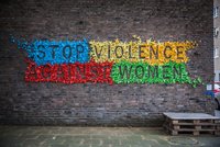 Ein aus bunten Origami-Vögeln gebastelter Schriftzug an einer Hauswand: Stop violence against women