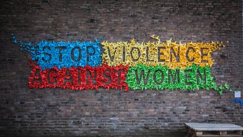 Slogan stop violence against women on a brick wall