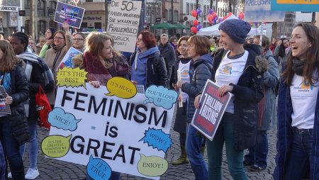 Mehrere Frauen mit einem Plakat mit der Aufschrift “Feminism is great”. 