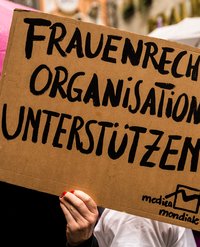 Auf einem Pappschild steht in schwarzer Schrift "Frauenrechtsorganisationen unterstützen"