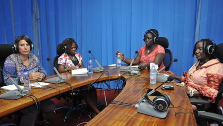 Four women are sitting in a studio during the recording of a radio program.