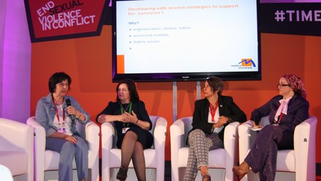 Four women sitting in armchairs as they take part in a podium discussion at the event "End Sexual Violence in Conflict”. From left to right are Fehmije Luzha, psychosocial counsellor at Medica Gjakova, Veprore Shehu, Director of Medica Kosova, Monika Hauser, founder of medica mondiale and Sabiha Husic, Director of Medica Zenica.