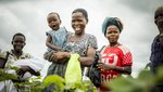 Eine Gruppe von Frauen mit kleinen Kindern bei der Feldarbeit in Uganda.