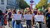 Drei Frauen auf einer Demonstration mit Schildern in der Hand