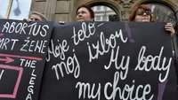 Eine Gruppe Frauen hält ein schwarzes Plakat mit weißer Schrift hoch, auf dem "my body my choice" steht