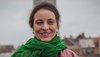 Eine Frau mit einem grünem Schal steht auf einer Dachterrasse mit Kölner Dom im Hintergrund. Es ist Sybille Fezer, Geschäftsführender Vorstand Internationale Programme bei medica mondiale.
