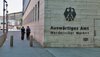 Zwei Menschen in Polizeiuniform laufen am Auswärtigen Amt in Berlin vorbei