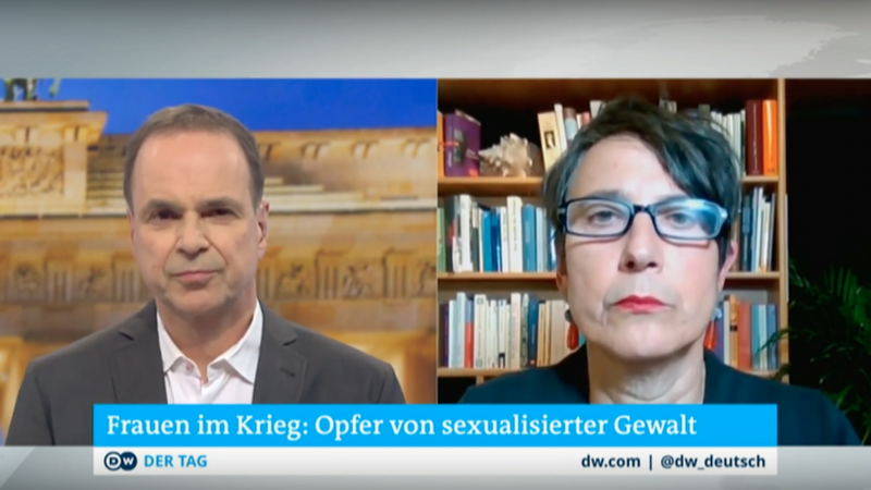Video-Screenshot: Links ist der Moderator in seinem Studio zu sehen, rechts Monika Hauser vor einem Bücherregal.