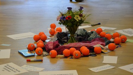 Photo of accessories used during a training course: anti-stress balls, notes from a brainstorming, and a flower arrangement in the middle.