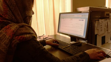 A woman working at a laptop.