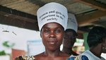 Eine Frau trägt ein Schild auf dem Kopf mit der Aufschrift ”Women and girls are important in the society” (deutsch: Frauen und Mädchen sind wichtig in der Gesellschaft) 
