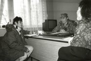 Monika Hauser sits opposite a Bosnian commander at his desk, black and white photo