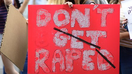 A placard at a demonstration. The slogan “Don’t get raped” has been crossed out and replaced to read “Don’t rape”.
