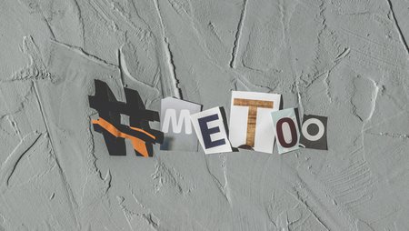 Letters cut out of coloured paper are used to form the hashtag #metoo on the wall of a building.