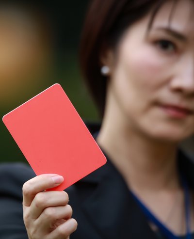 Eine Frau hält eine rote Karte in die Kamera