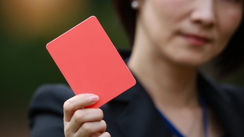 A woman is holding a red card.