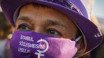 Nahaufnahme des Gesichts einer Frau mit lilafarbenem Hut und lilafarbenem Mundschutz mit der tükischen Aufschrift İstanbul Sözleşmesi uygula! Was auf Deutsch soviel wie Istanbul Konvention umsetzten heißt.
