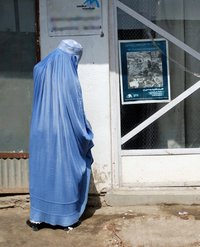 Eine afghanische Frau vor einem geschlossenen Mediationszentrum.
