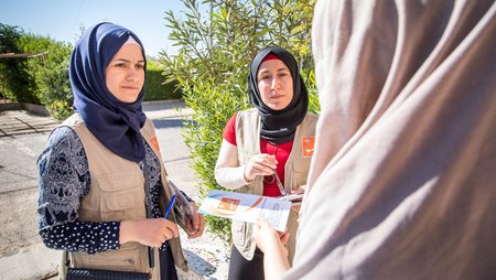 Mitarbeiterinnen einer Frauenrechtsorganisation klären in Flüchtlingslagern über das Coronaviurs auf.