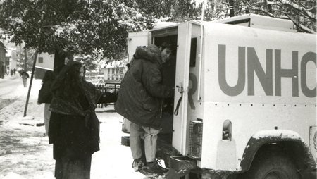 Black and white picture of Monika Hauser entering a UNHCR vehicle